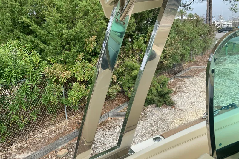 Slide: The Image of 2019 Chris-Craft Catalina 27 boat detail with chrome accents and lush greenery background. - 42