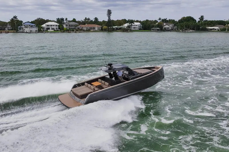 Slide: The Image of 2024 Pardo Yachts P43 cruising on a scenic waterway near luxury homes. - 4
