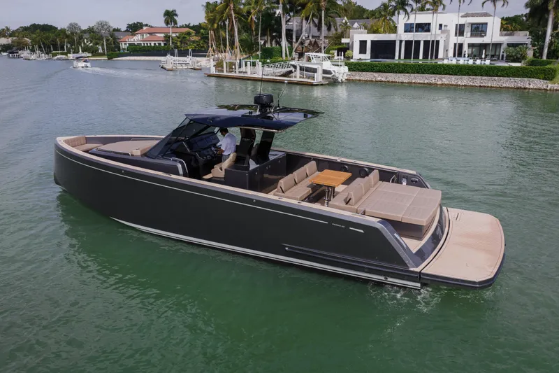 Slide: The Image of 2024 Pardo Yachts P43 cruising on a scenic waterway near luxury homes. - 9