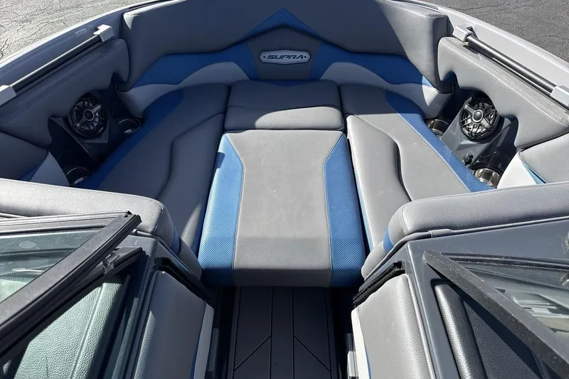 Slide: The Image of 2019 Supra SR boat interior with gray and blue seating, featuring built-in speakers. - 11
