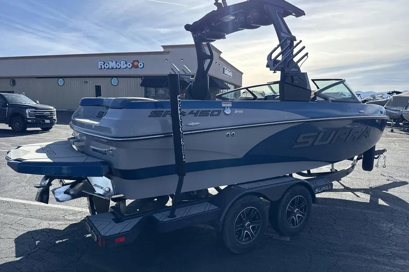 Slide: The Image of 2019 Supra SR boat on trailer in parking lot, showcasing sleek design and modern features. - 5