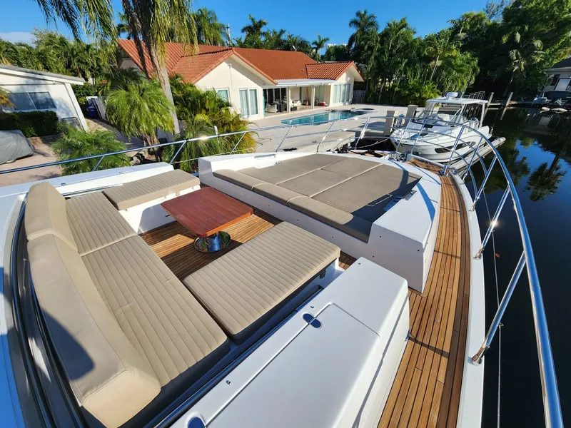 Slide: The Image of Azimut 77S 2019 yacht with spacious deck seating and table, docked near a luxurious waterfront home. - 9