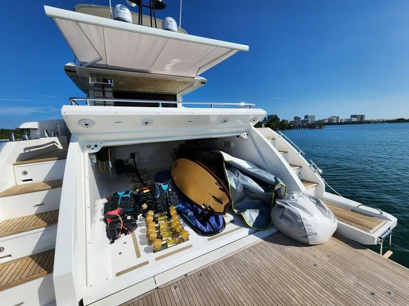 Slide: The Image of 2019 Azimut 77S yacht with open storage compartment, water sports gear, and scenic waterfront view. - 39