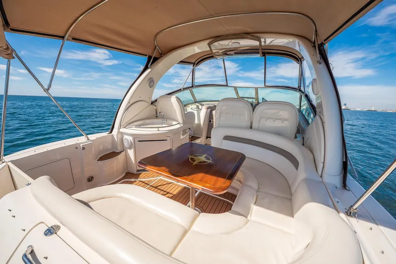 Slide: The Image of 2003 Sea Ray 340 Sundancer yacht interior with seating and table on open water. - 12