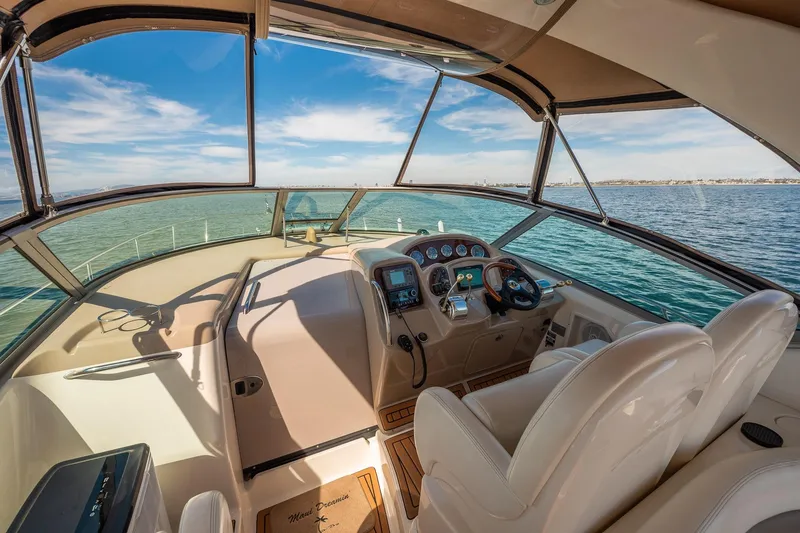 Slide: The Image of 2003 Sea Ray 340 Sundancer cockpit with ocean view, featuring modern controls and seating. - 13