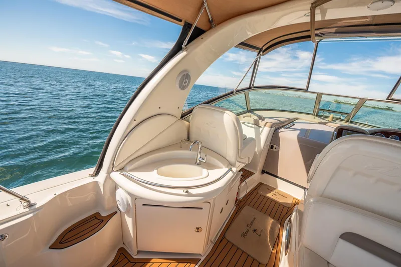 Slide: The Image of 2003 Sea Ray 340 Sundancer interior with ocean view, featuring helm and seating area. - 19