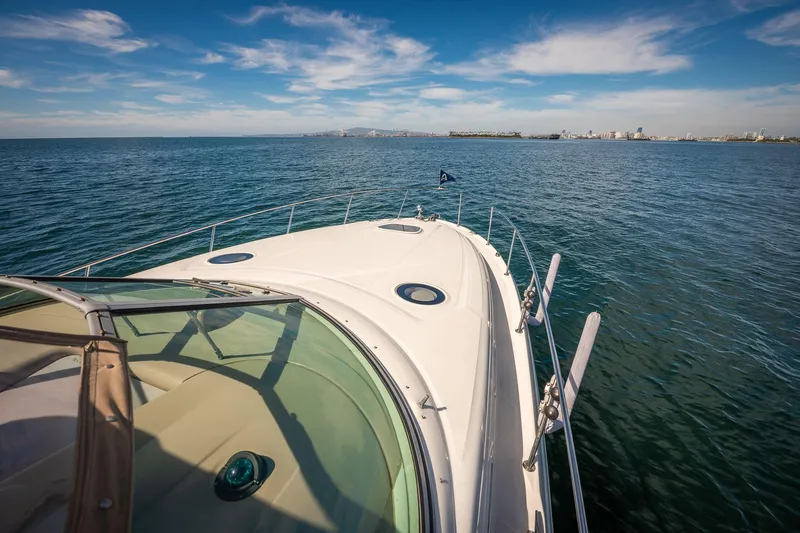 Slide: The Image of 2003 Sea Ray 340 Sundancer cruising on open water under a clear blue sky. - 26