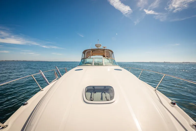 Slide: The Image of 2003 Sea Ray 340 Sundancer yacht cruising on open water under clear blue skies. - 29