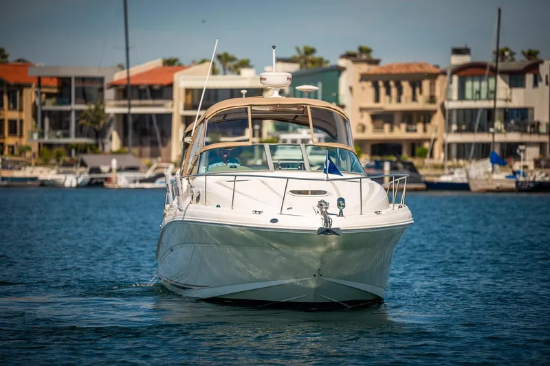 Slide: The Image of 2003 Sea Ray 340 Sundancer yacht cruising in a marina with waterfront homes. - 30