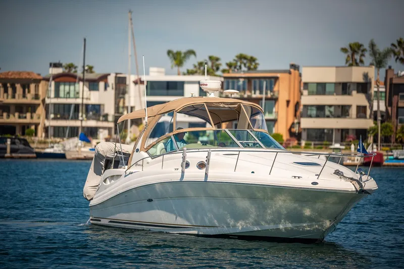 Slide: The Image of 2003 Sea Ray 340 Sundancer yacht cruising near modern waterfront homes. - 31