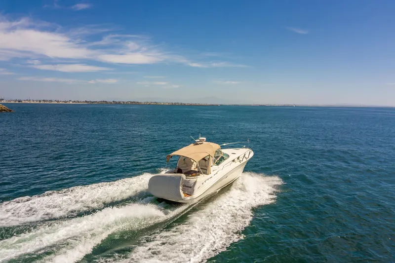 Slide: The Image of 2003 Sea Ray 340 Sundancer cruising on open water under clear blue skies. - 36