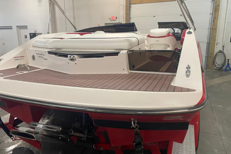 Slide: The Image of 2008 Regal 2000 Bowrider boat in a garage, showcasing rear deck and seating. - 2
