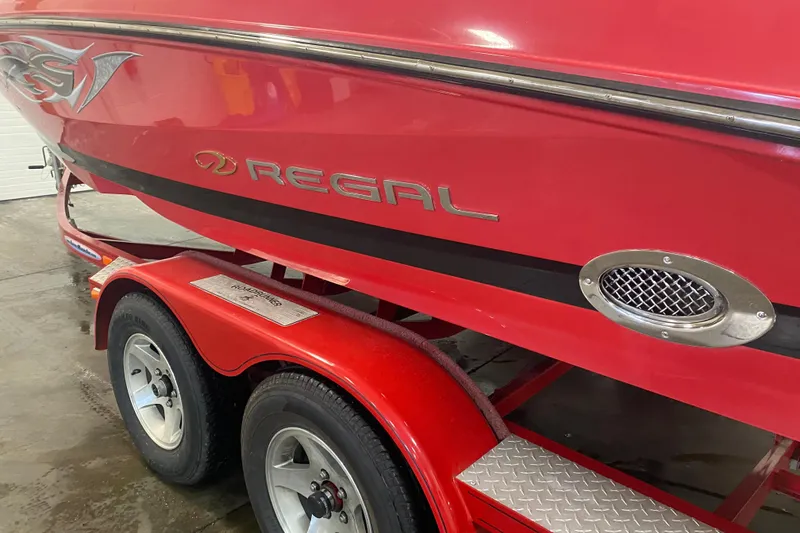 Slide: The Image of Red 2008 Regal 2000 Bowrider boat on trailer, showcasing sleek design and branding. - 5
