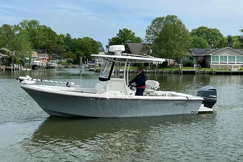 The Image of 2021 Parker 2300 DV Center Console boat on a calm lake near waterfront homes. - 0