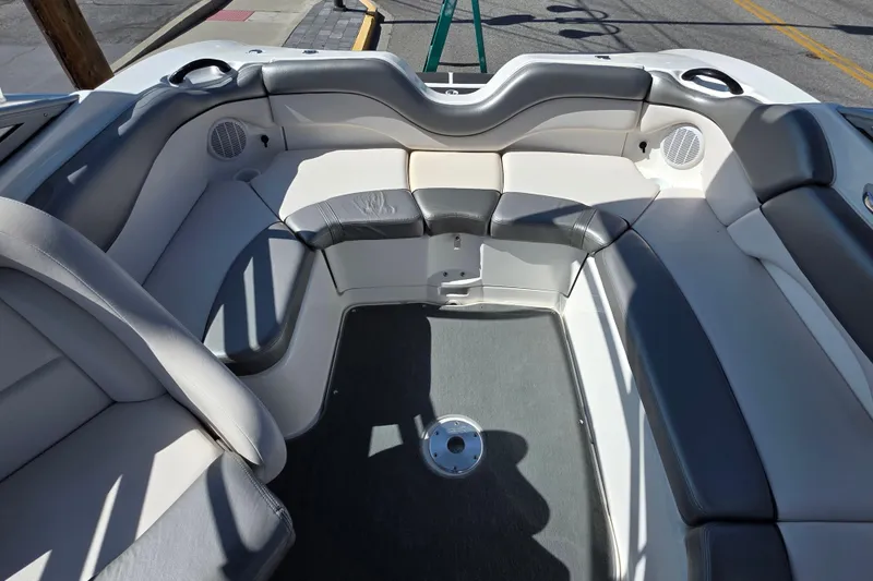 Slide: The Image of 2009 Yamaha Boats AR210 interior with gray and white seating, featuring speakers and cup holders. - 11