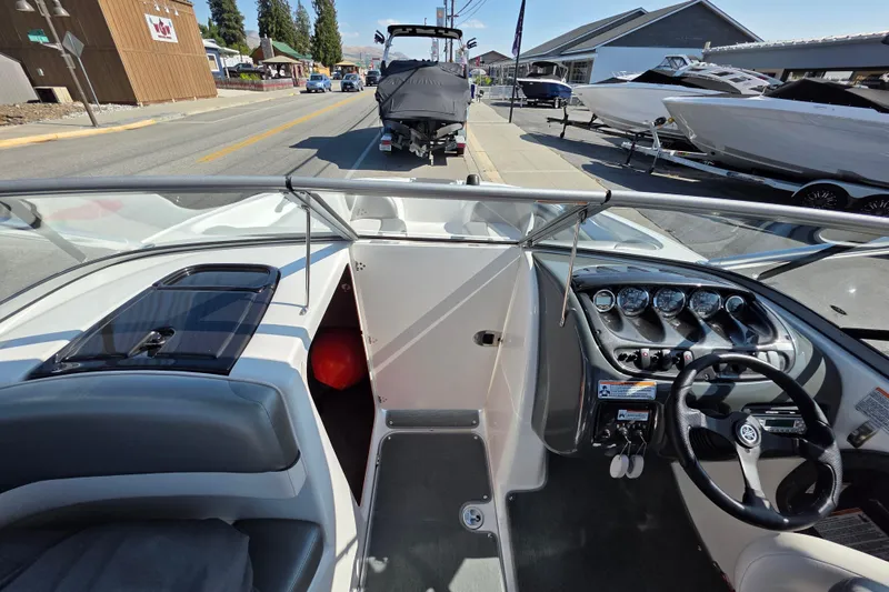 Slide: The Image of 2009 Yamaha Boats AR210 cockpit with steering wheel and dashboard, parked on a street. - 19