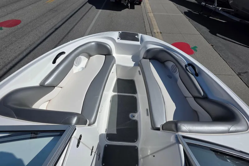 Slide: The Image of 2009 Yamaha Boats AR210 interior with gray and white seating, docked on a sunny day. - 20