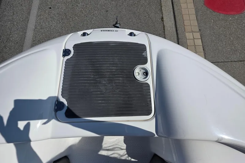 Slide: The Image of 2009 Yamaha AR210 boat deck with storage hatch, docked on pavement. - 23