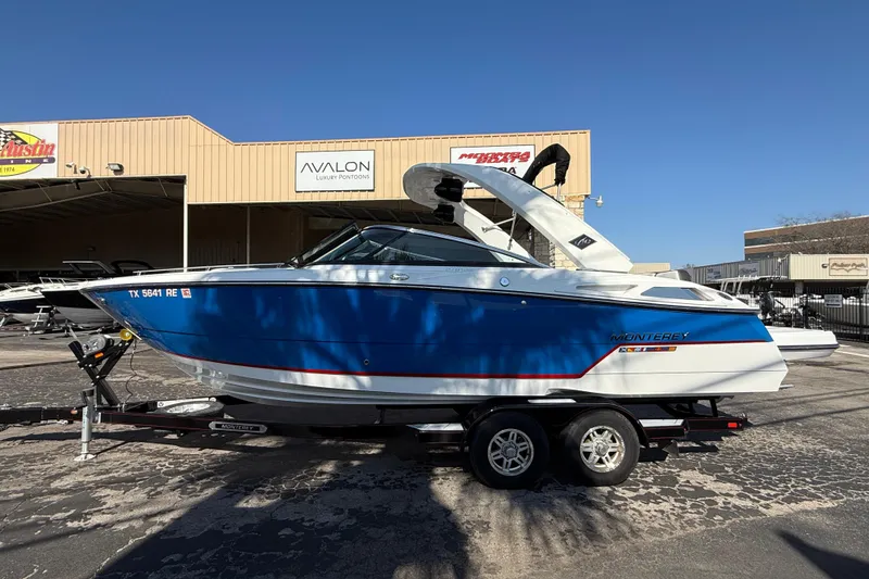 Slide: The Image of 2018 Monterey 278 SSC boat in blue and white on a trailer at a dealership. - 3
