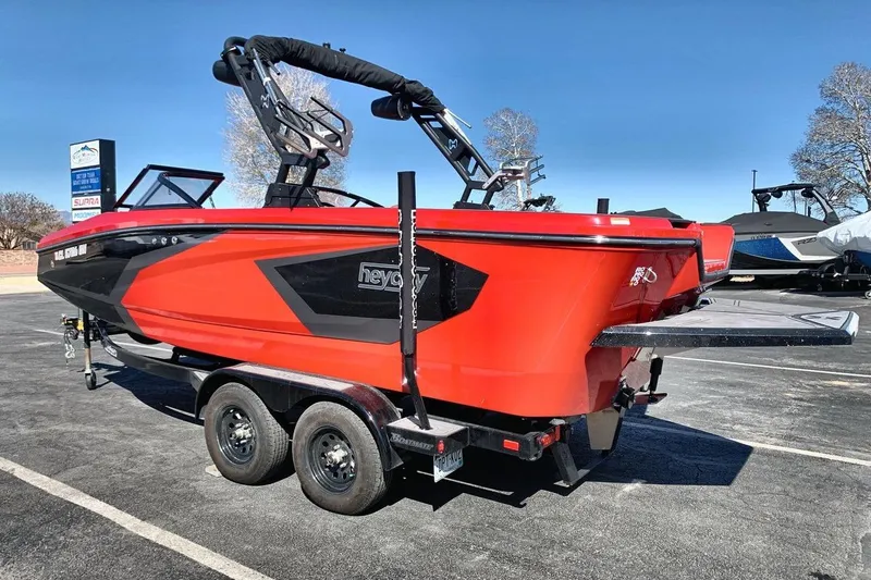 Slide: The Image of 2023 Heyday WT-2DC boat in vibrant red on a trailer, parked outdoors. - 13