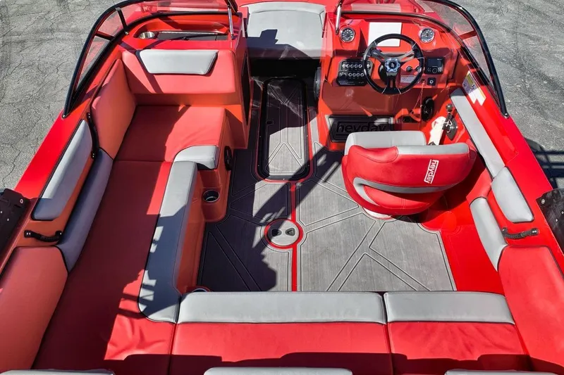 Slide: The Image of 2023 Heyday WT-2DC boat interior with red and gray seating, steering wheel, and dashboard. - 20