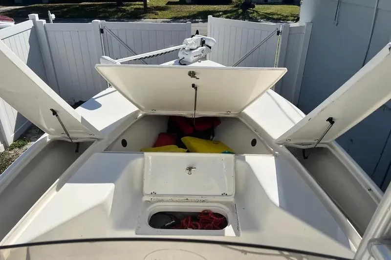 Slide: The Image of 2010 Key West 246 Bay Reef boat with open storage compartments and visible life jackets. - 12