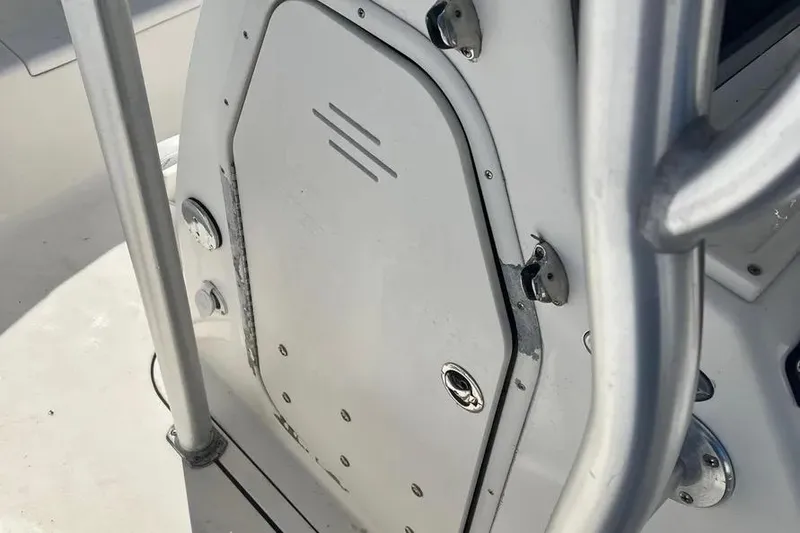 Slide: The Image of 2010 Key West 246 Bay Reef boat console with metal railings and storage compartment. - 19