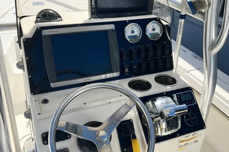 Slide: The Image of 2010 Key West 246 Bay Reef boat dashboard with steering wheel and navigation instruments. - 20