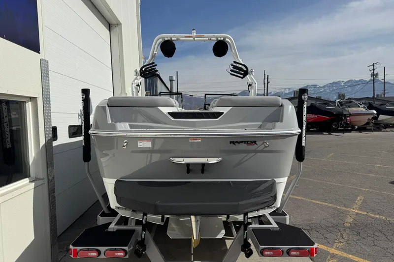 Slide: The Image of 2026 Moomba Max boat on trailer, rear view, parked outdoors with mountains in background. - 2