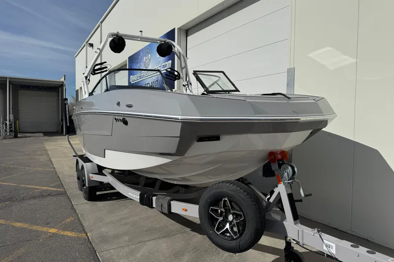 Slide: The Image of 2026 Moomba Max boat on trailer, parked outside a building under clear skies. - 3