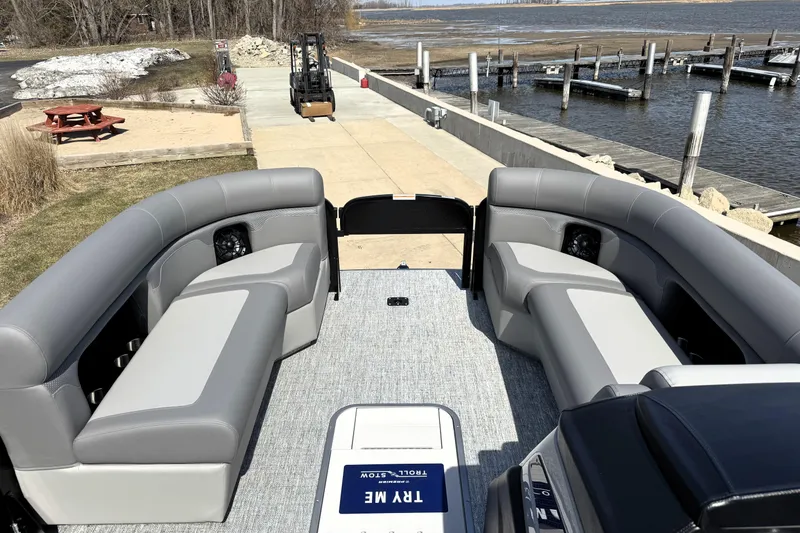 Slide: The Image of 2026 Premier 230 Sunsation Angler 2pt pontoon boat interior with gray seating near a dock. - 20