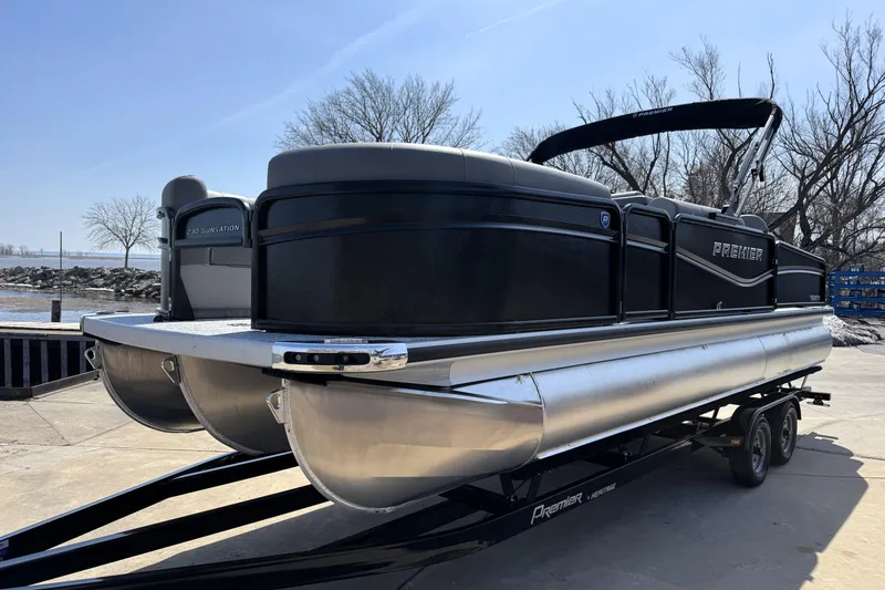 Slide: The Image of 2026 Premier 230 Sunsation Angler 2pt pontoon boat on trailer, dockside view. - 6