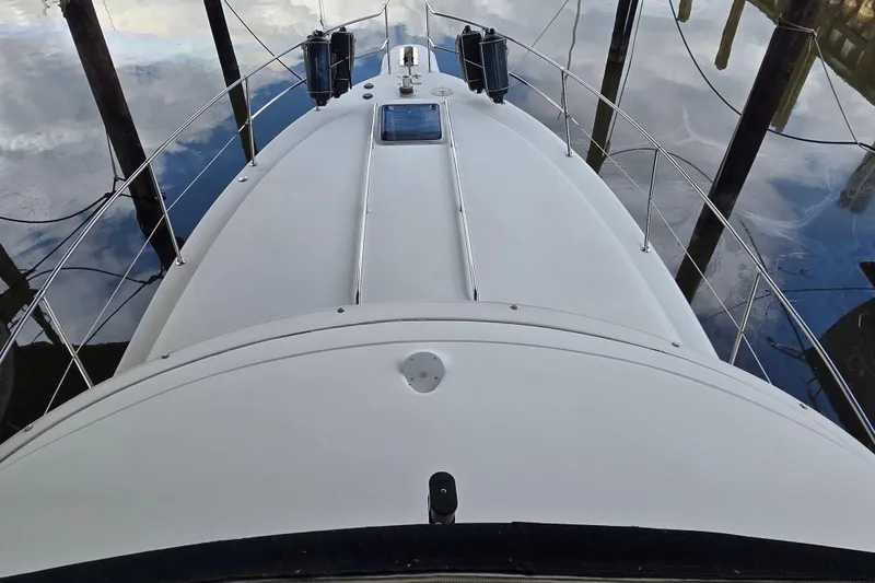 Slide: The Image of 1994 Sea Ray 370 Sedan Bridge docked at marina, featuring upper deck and American flag. - 3