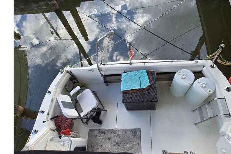 Slide: The Image of 1994 Sea Ray 370 Sedan Bridge yacht docked, viewed from above, reflecting on calm water. - 4