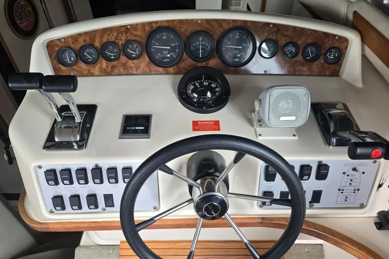 Slide: The Image of 1994 Sea Ray 370 Sedan Bridge helm with steering wheel, controls, and navigation equipment. - 9