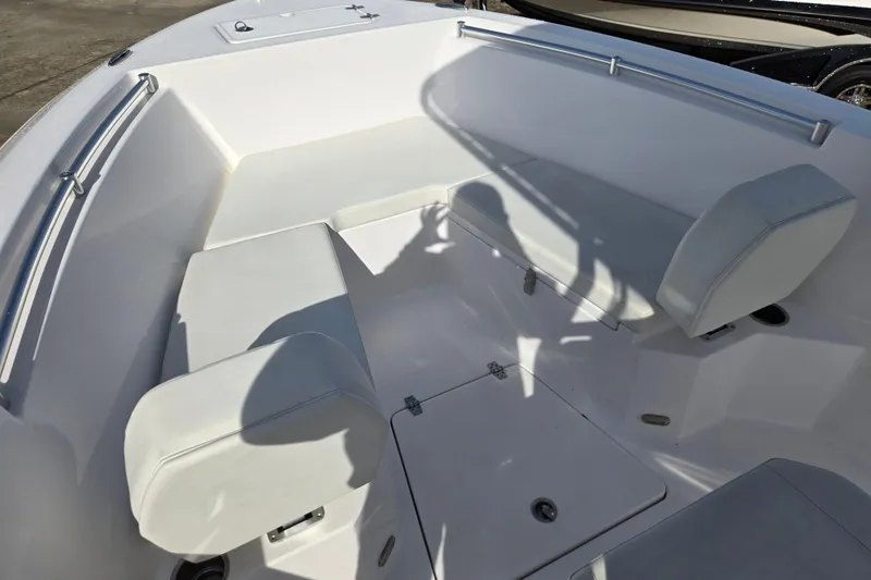 Slide: The Image of 2024 Aquasport 2200 Center Console boat interior with white seating and storage compartments. - 10