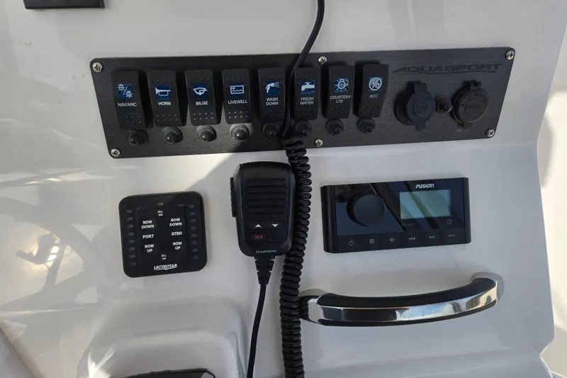 Slide: The Image of 2024 Aquasport 2200 Center Console dashboard with control panel and radio system. - 11