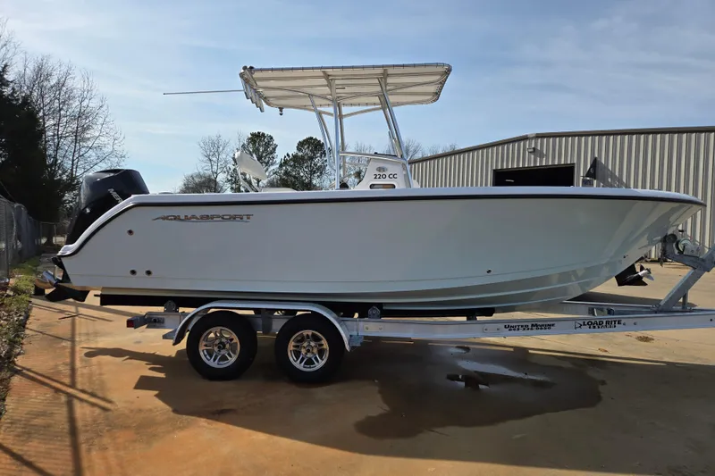Slide: The Image of 2024 Aquasport 2200 Center Console boat on trailer, side view. - 2