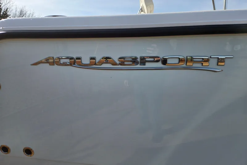 Slide: The Image of 2024 Aquasport 2200 Center Console boat logo on white hull. - 3