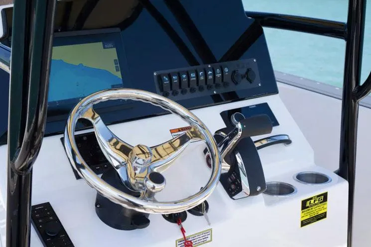 Slide: The Image of Manufacturer Provided Image: 2024 Aquasport 2200 Center Console boat dashboard with steering wheel and navigation screen. - 30
