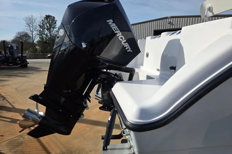 Slide: The Image of 2024 Aquasport 2200 Center Console with Mercury outboard engine, parked outdoors. - 4