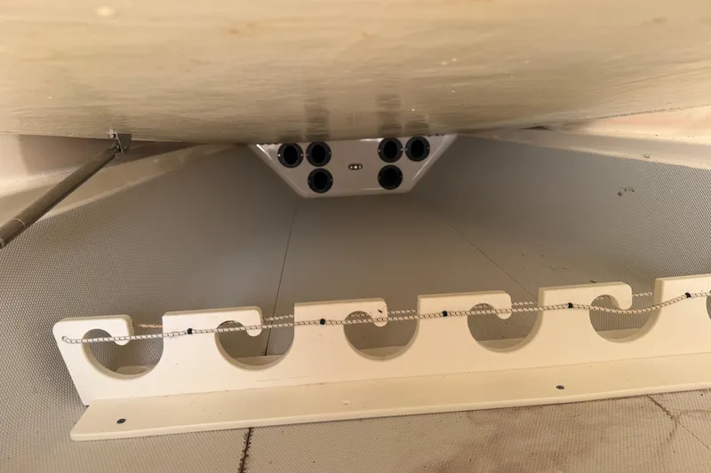 Slide: The Image of 2015 Cobia 344 Center Console boat storage compartment with rod holders. - 109