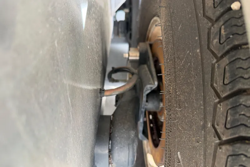 Slide: The Image of Close-up of a 2015 Cobia 344 Center Console trailer wheel and suspension. - 11