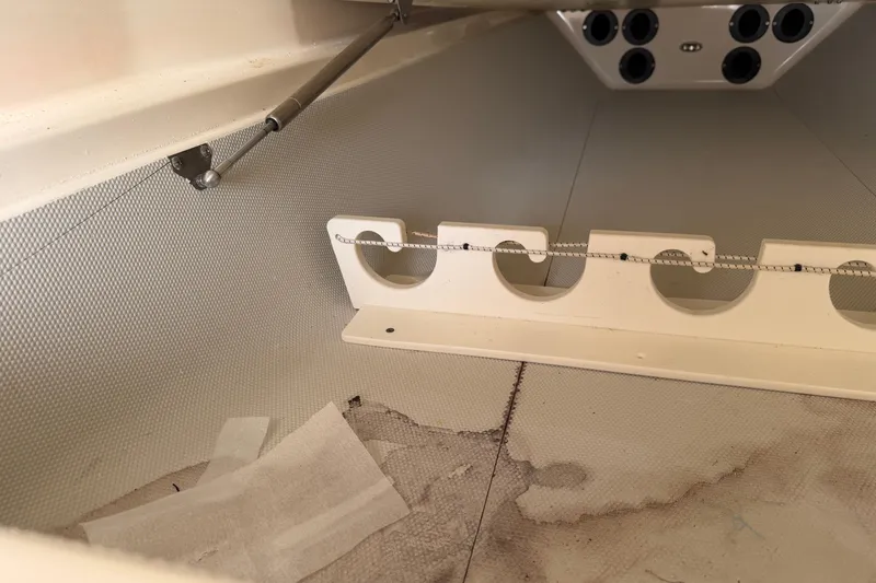 Slide: The Image of Interior view of a 2015 Cobia 344 Center Console boat, featuring rod holders and storage area. - 110