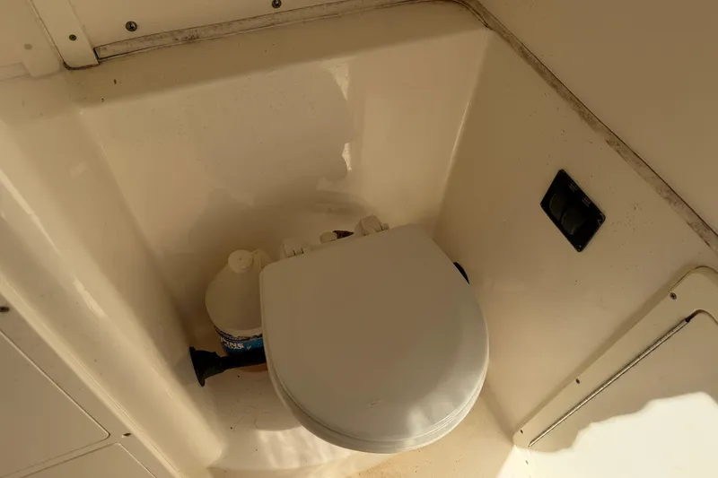 Slide: The Image of 2015 Cobia 344 Center Console boat toilet area with cleaning supplies. - 116