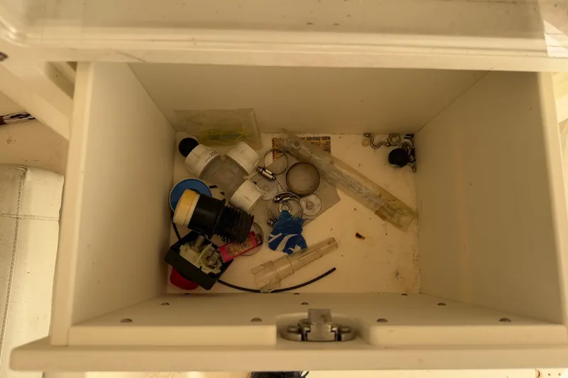 Slide: The Image of Storage compartment with miscellaneous items on a 2015 Cobia 344 Center Console boat. - 118