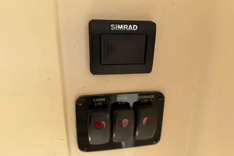 Slide: The Image of Simrad switch panel on 2015 Cobia 344 Center Console boat, featuring cabin, bunk, storage lights. - 122