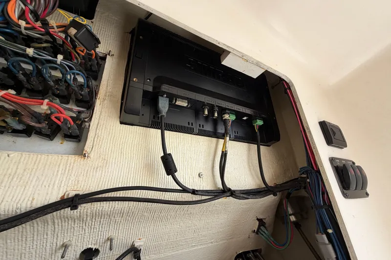 Slide: The Image of 2015 Cobia 344 Center Console wiring and electronic connections inside a compartment. - 125