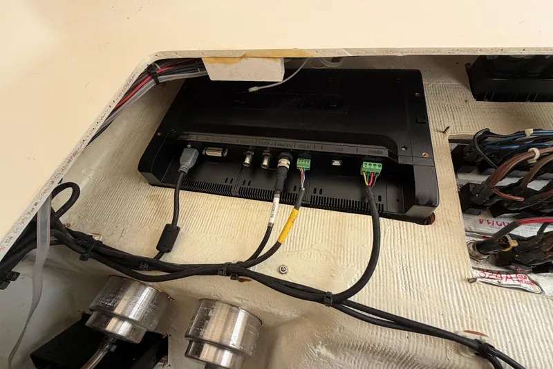 Slide: The Image of 2015 Cobia 344 Center Console electronics compartment with wiring and connections. - 127