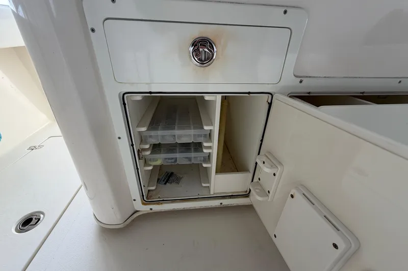 Slide: The Image of 2015 Cobia 344 Center Console storage compartment with open door and organized shelves. - 139